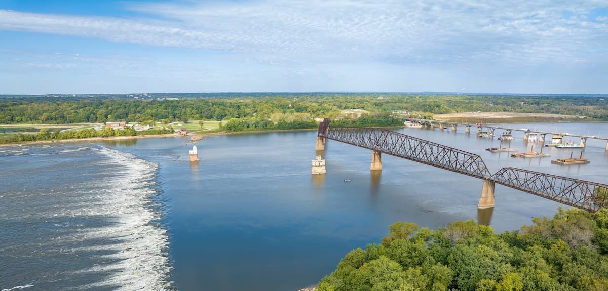 an aerial view of a bridge over the mississippi river surrounded by trees .