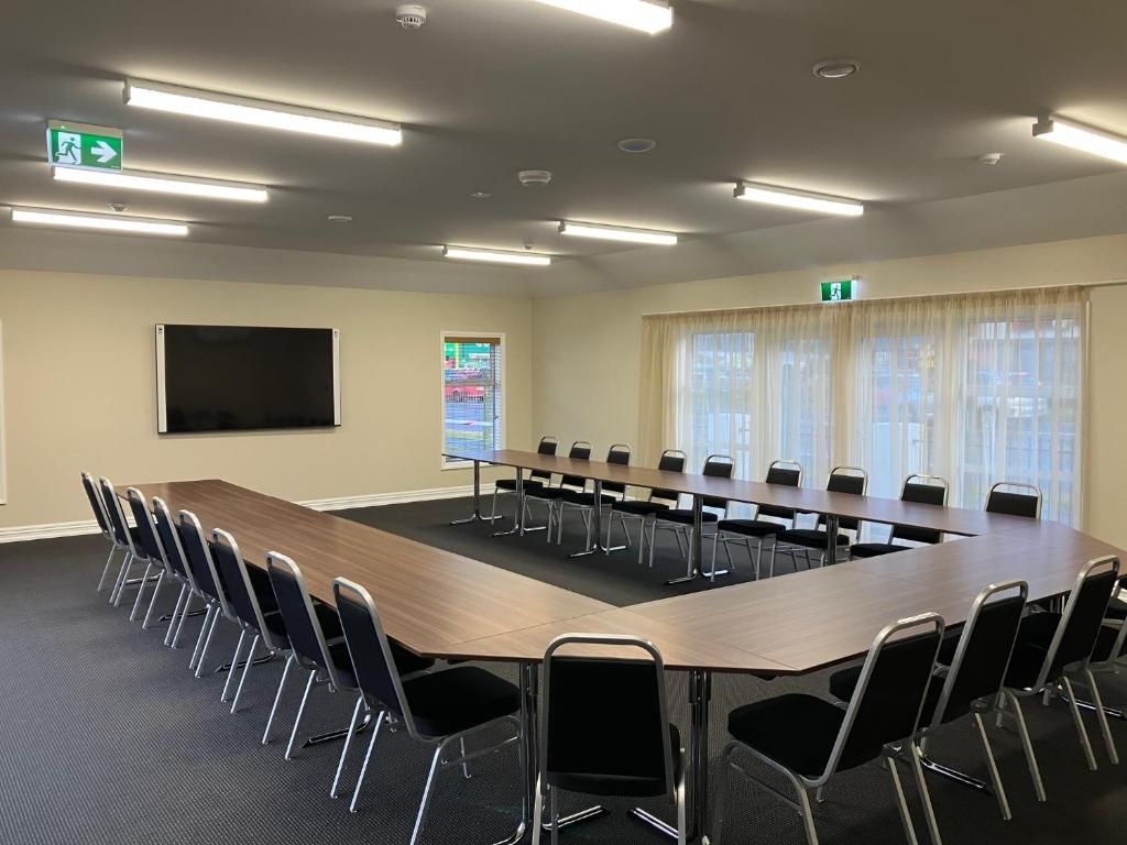 A large conference room with a long table and chairs.