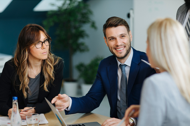 A group of business people are sitting at a table having a meeting.