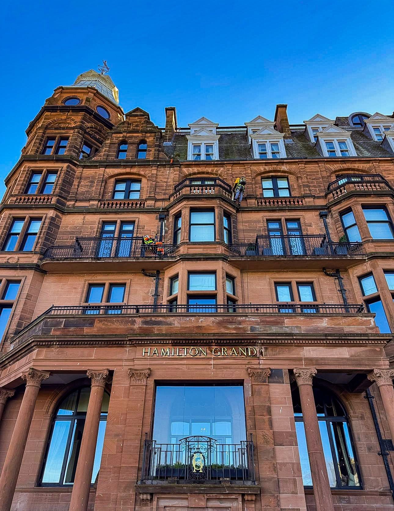 A low-angle view of the red sandstone facade of the Hamilton Grand private residence in St Andrews