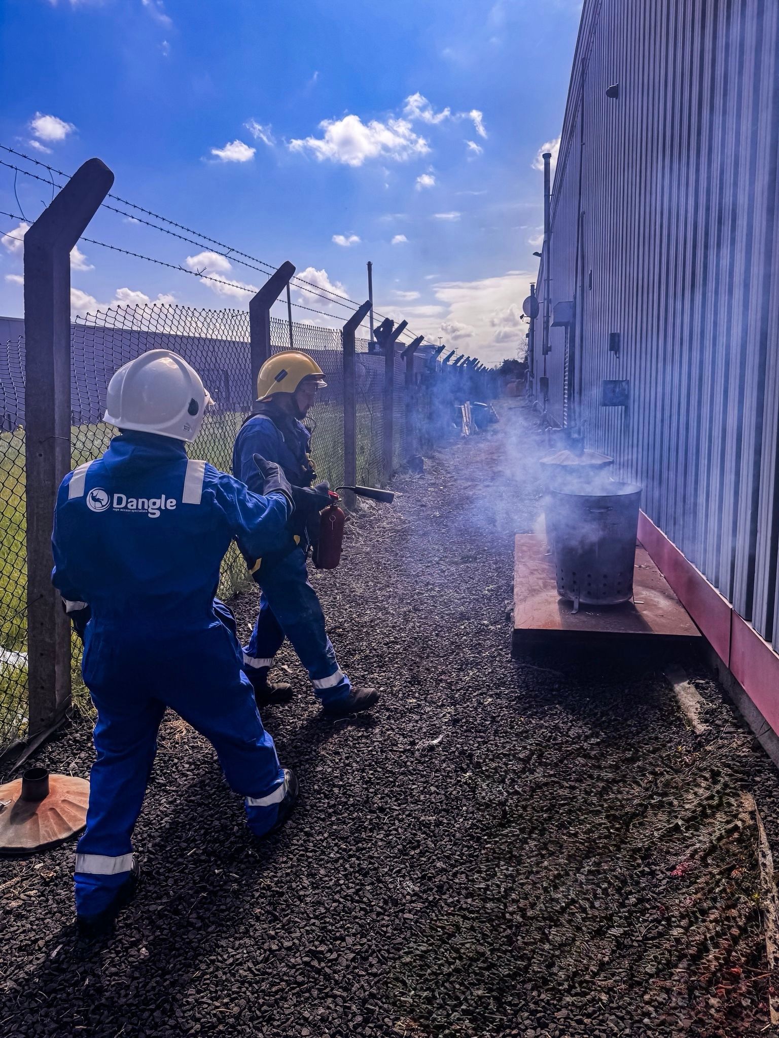Dangle Academy student and instructor in blue suits spraying water in fire awareness training in Belfast