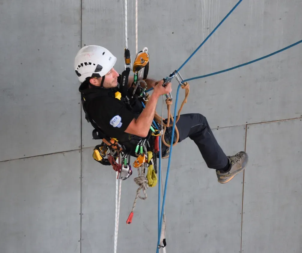 Technician suspended on twin-rope system performing manoeuvres. 