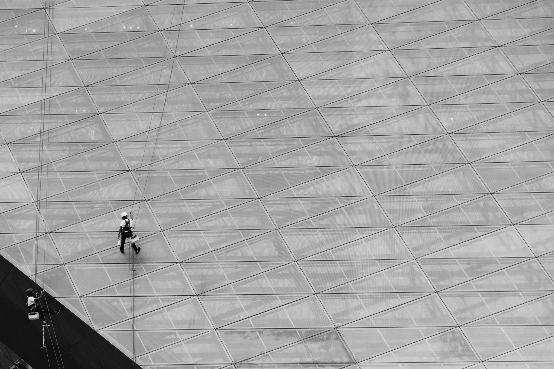 A black and white photo of a person walking on a tiled floor.
