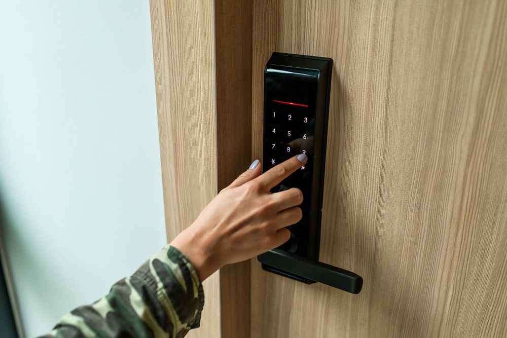 A Woman is Pressing a Button on a Door Lock — Ontime Locksmiths & Security In Mullumbimby, NSW