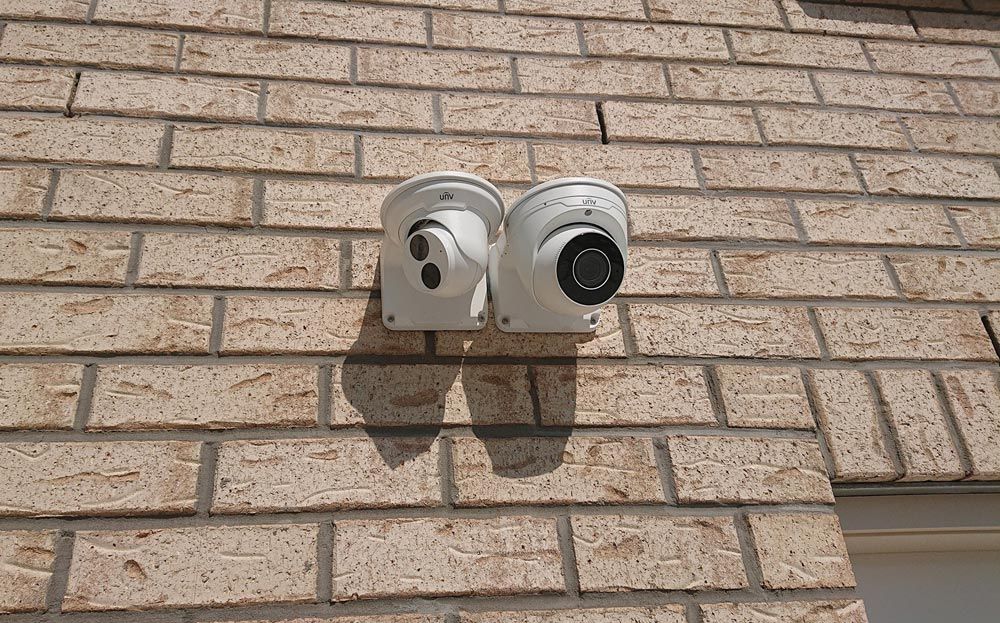 Two Security Cameras Mounted Side By Side On A Brick Wall — Ontime Locksmiths & Security In Mullumbimby, NSW
