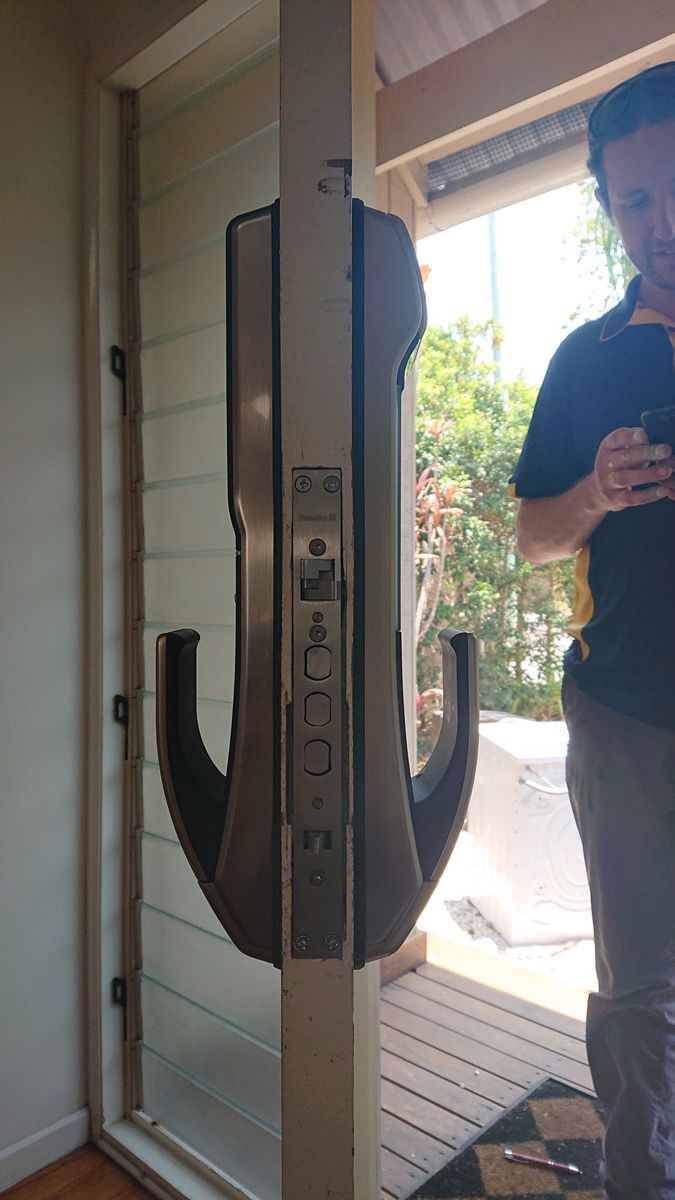 Man Standing In Front Of An Open Door With A Lock And Handle — Ontime Locksmiths & Security In Ocean Shores, NSW