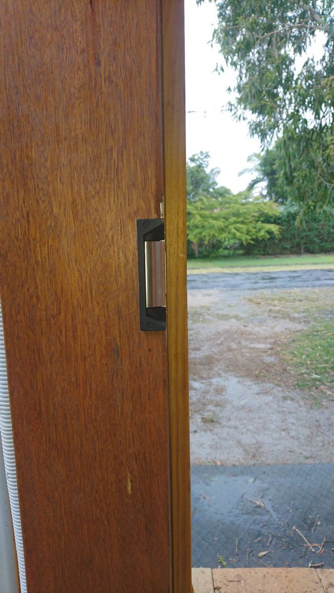 Wooden Door With A Black Handle And Trees Outside — Ontime Locksmiths & Security In Ocean Shores, NSW