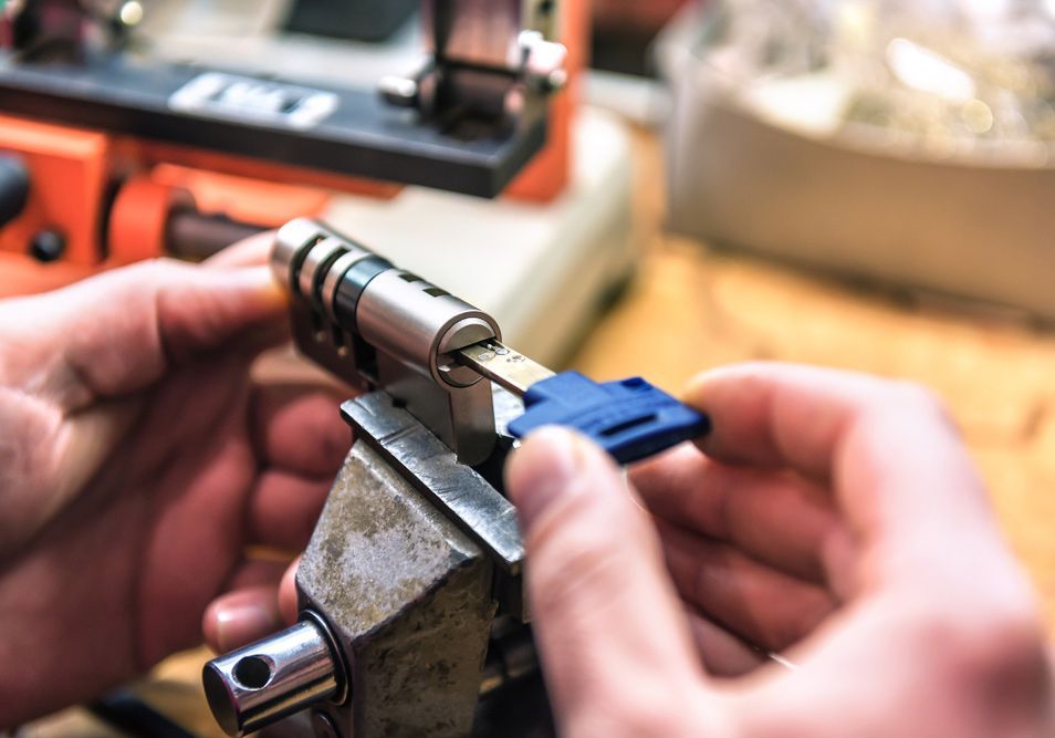 A Man Is Working On A Key And Lock Pair Placed On A Vice — Ontime Locksmiths & Security In Byron Bay, NSW