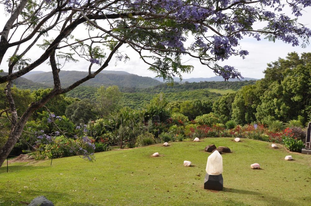 Lush Green Field With Mountains And A White Stone Placed On A Black Stone — Security Systems In Mullumbimby, NSW
