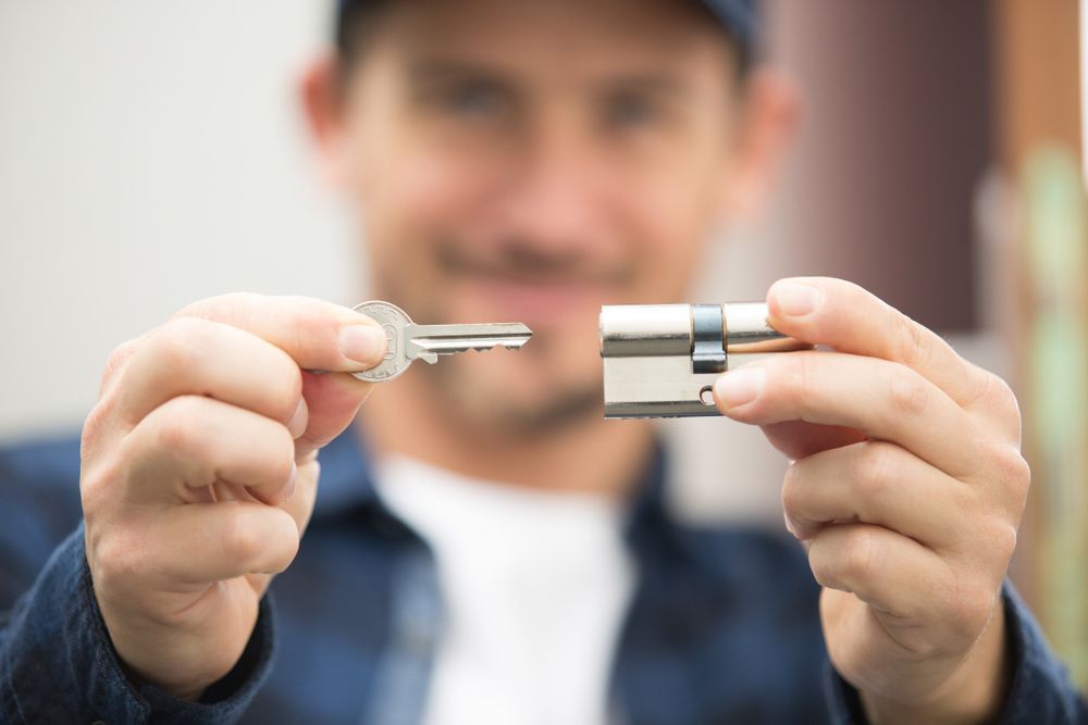 A Man Holding A Key And A Lock, Inserting Key In The Lock — Ontime Locksmiths & Security In Brunswick Heads, NSW