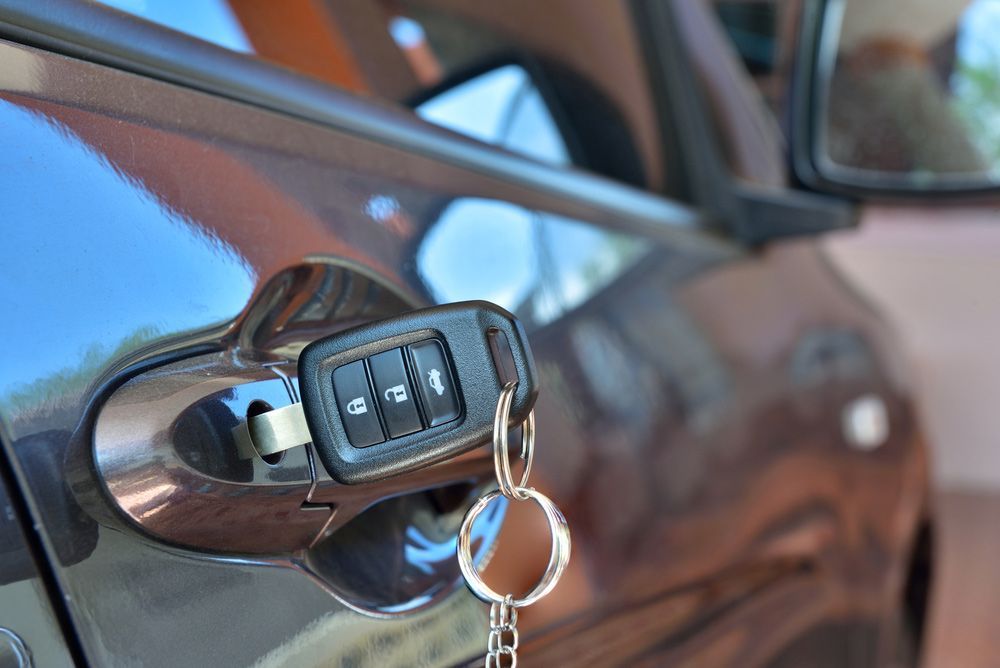Black Car With Key Inserted In The Door Lock — Ontime Locksmiths & Security In Ocean Shores, NSW