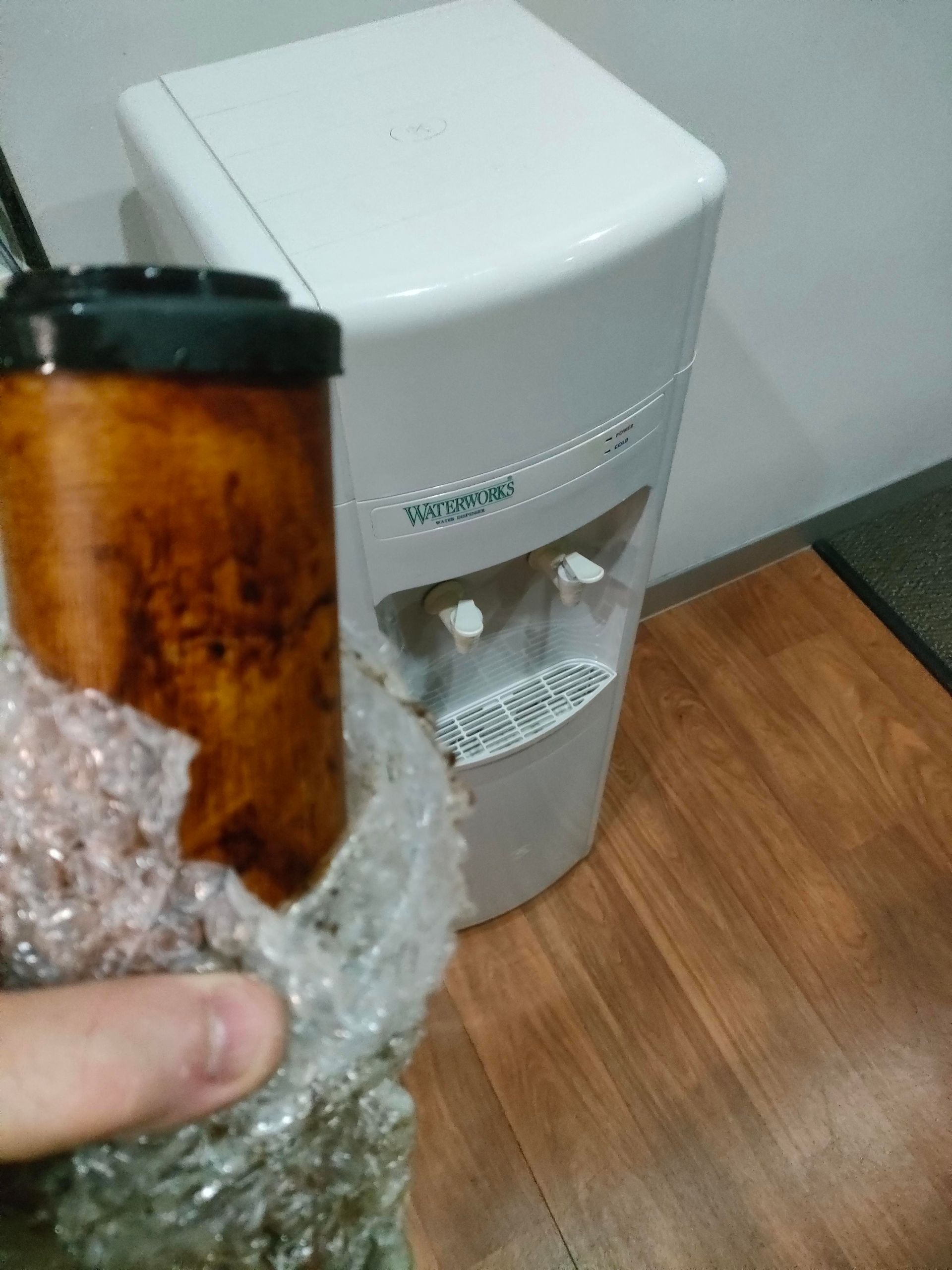 A man is fixing a water filter in a kitchen — Cairns Clear Water Company In Westcourt, QLD