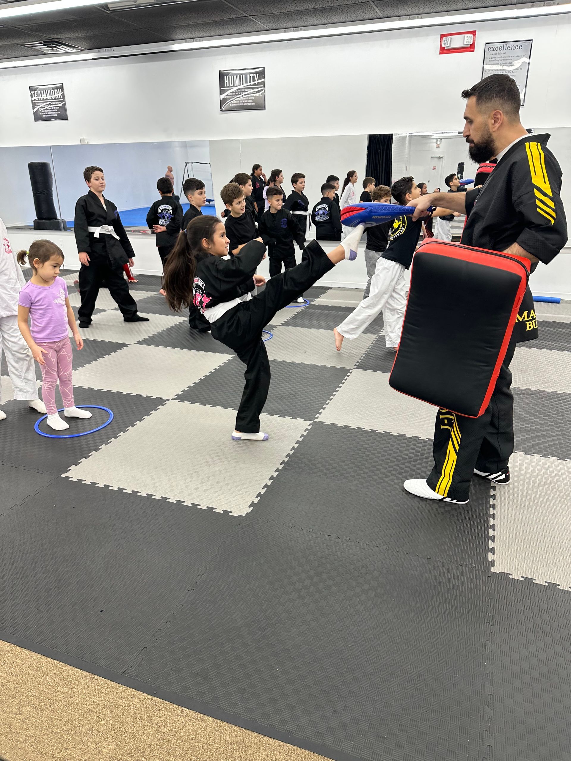 Martial arts class with students kicking pads in a training studio