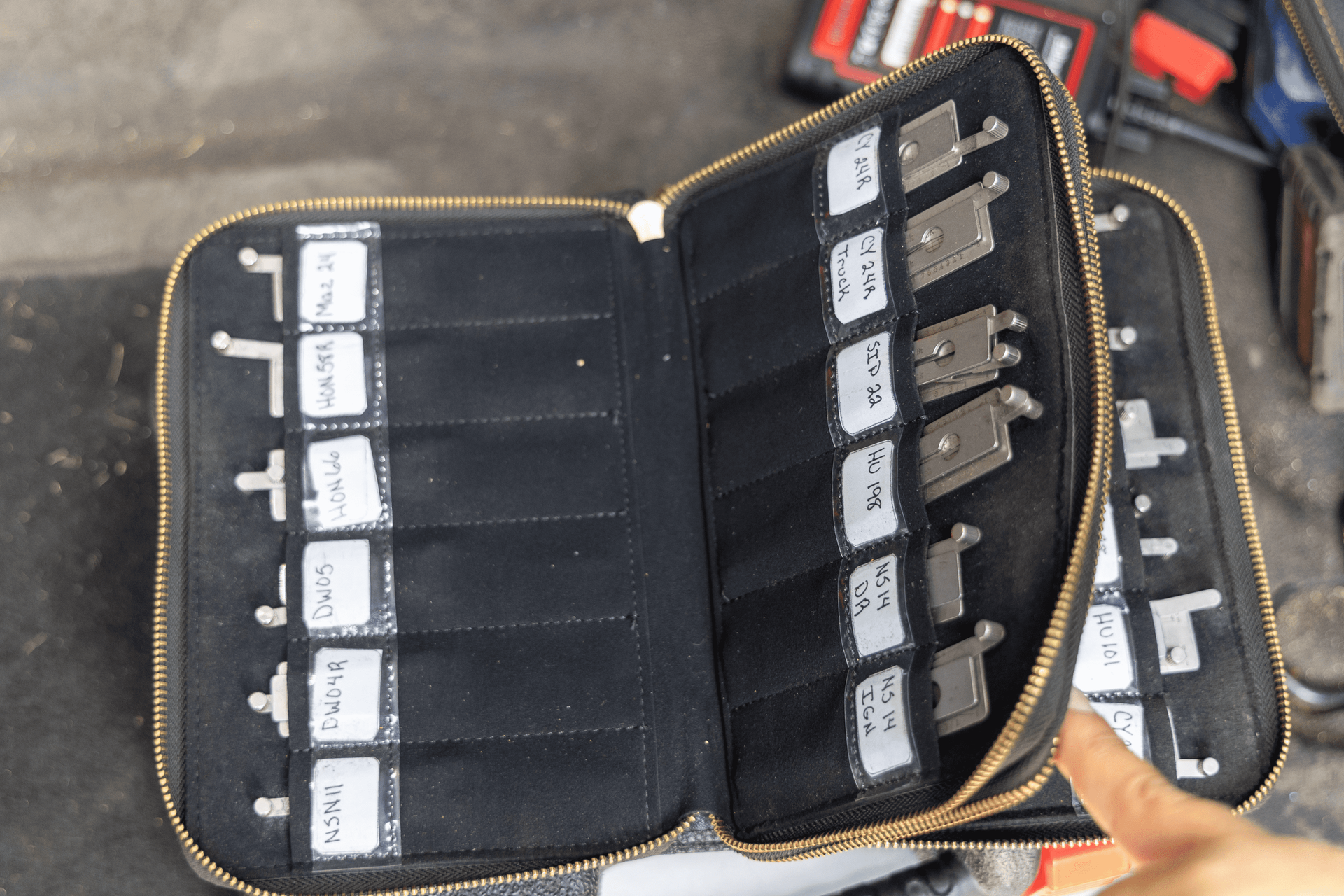 A person is holding a zipper case filled with keys.