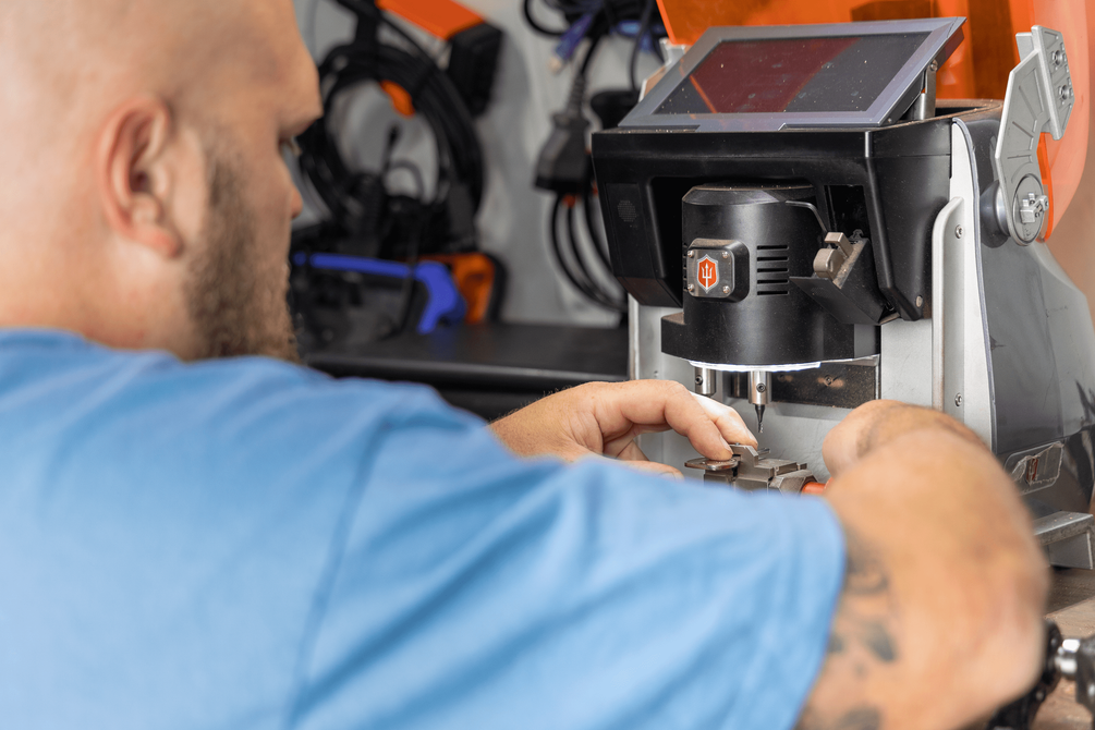 A man is using a machine to make a key.