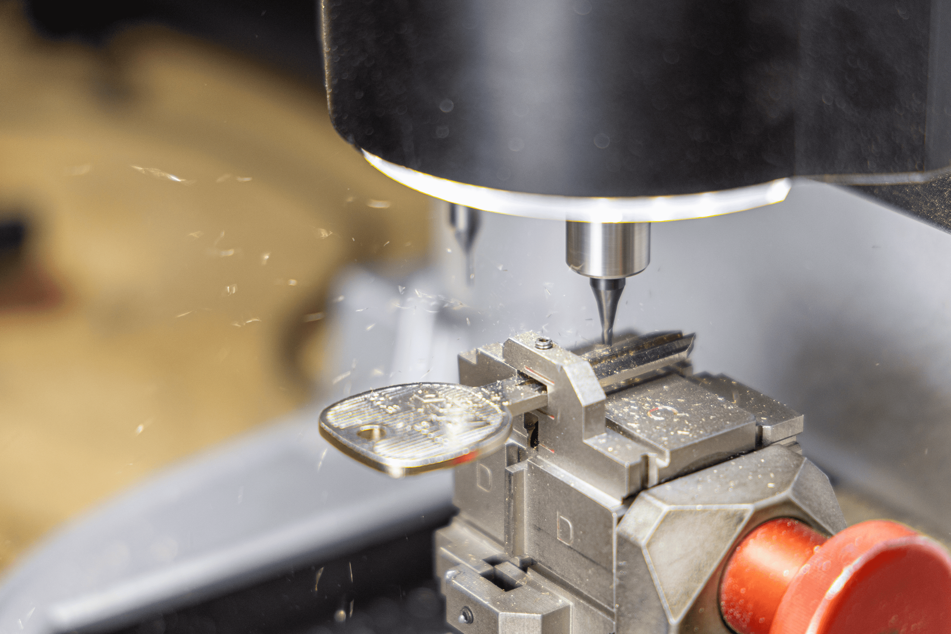 A machine is cutting a key on a table.
