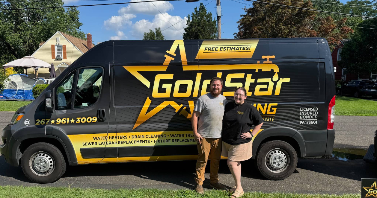 Two people stand by a black van with