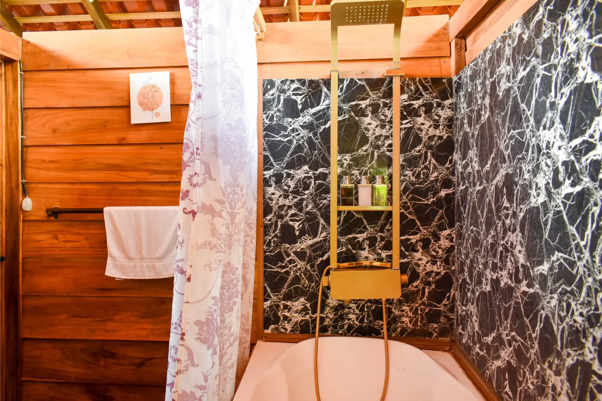 Bathroom with wooden walls, a tub, and a decorative black and silver wall.