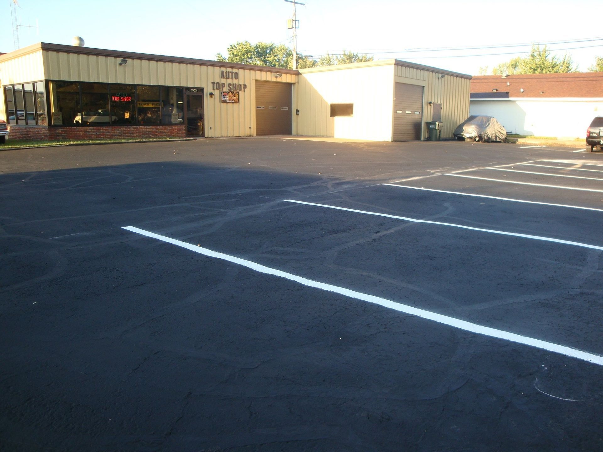 A business building with a parking lot, featuring white parking lines.