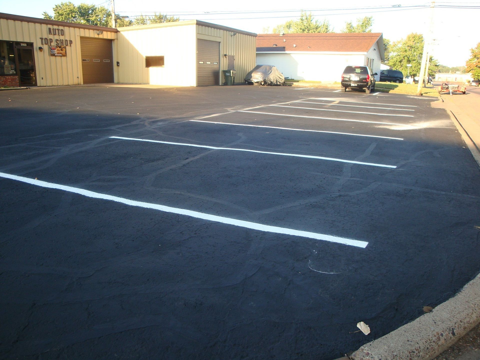 Empty parking lot with freshly painted white lines in front of a brick building.