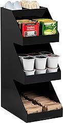 A black shelf filled with coffee pods , sugar cubes , and spoons.