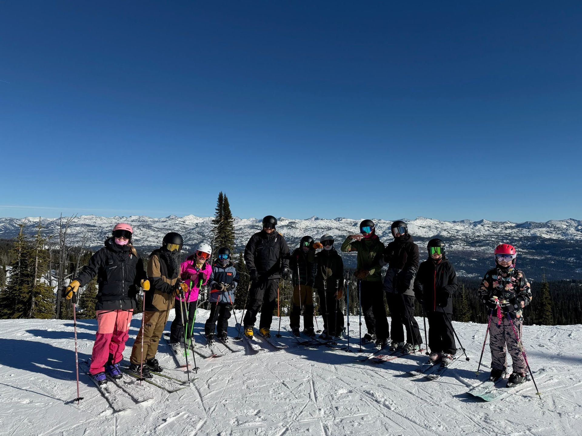 Skier in red pants and helmet jumps through powder on a bright snowy mountain slope.