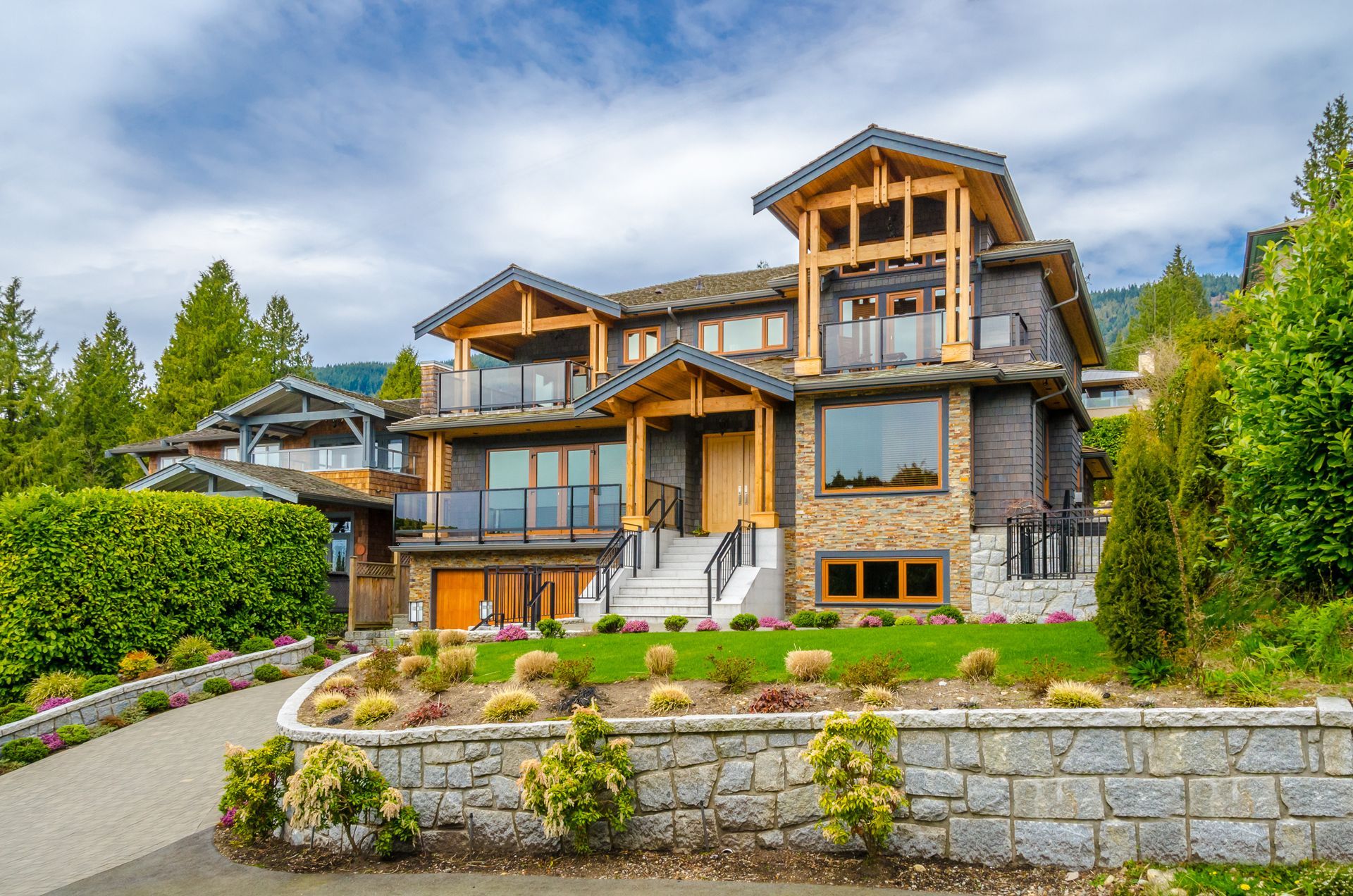 Luxury house with stone facade, wood accents, and a manicured lawn.