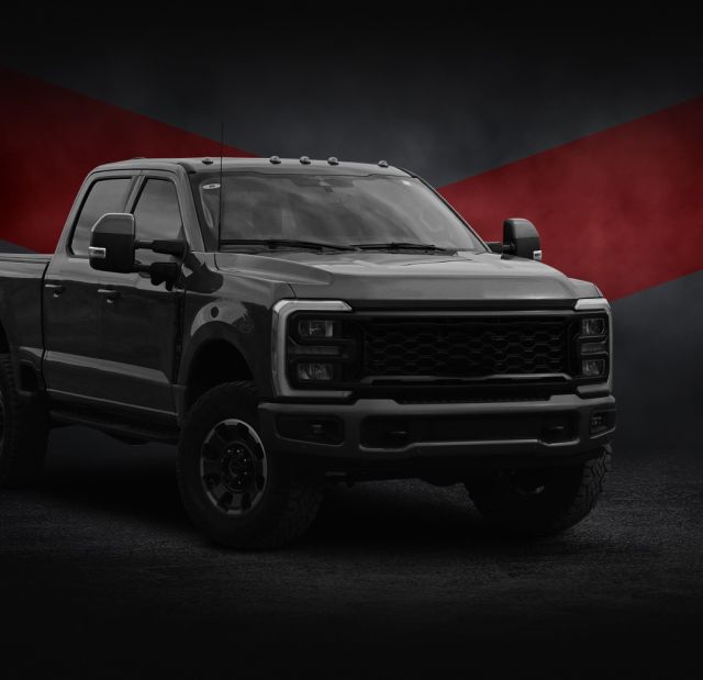 Three dark vehicles on a black stage with red lighting: a pickup, SUV, and sports car | RMP Auto