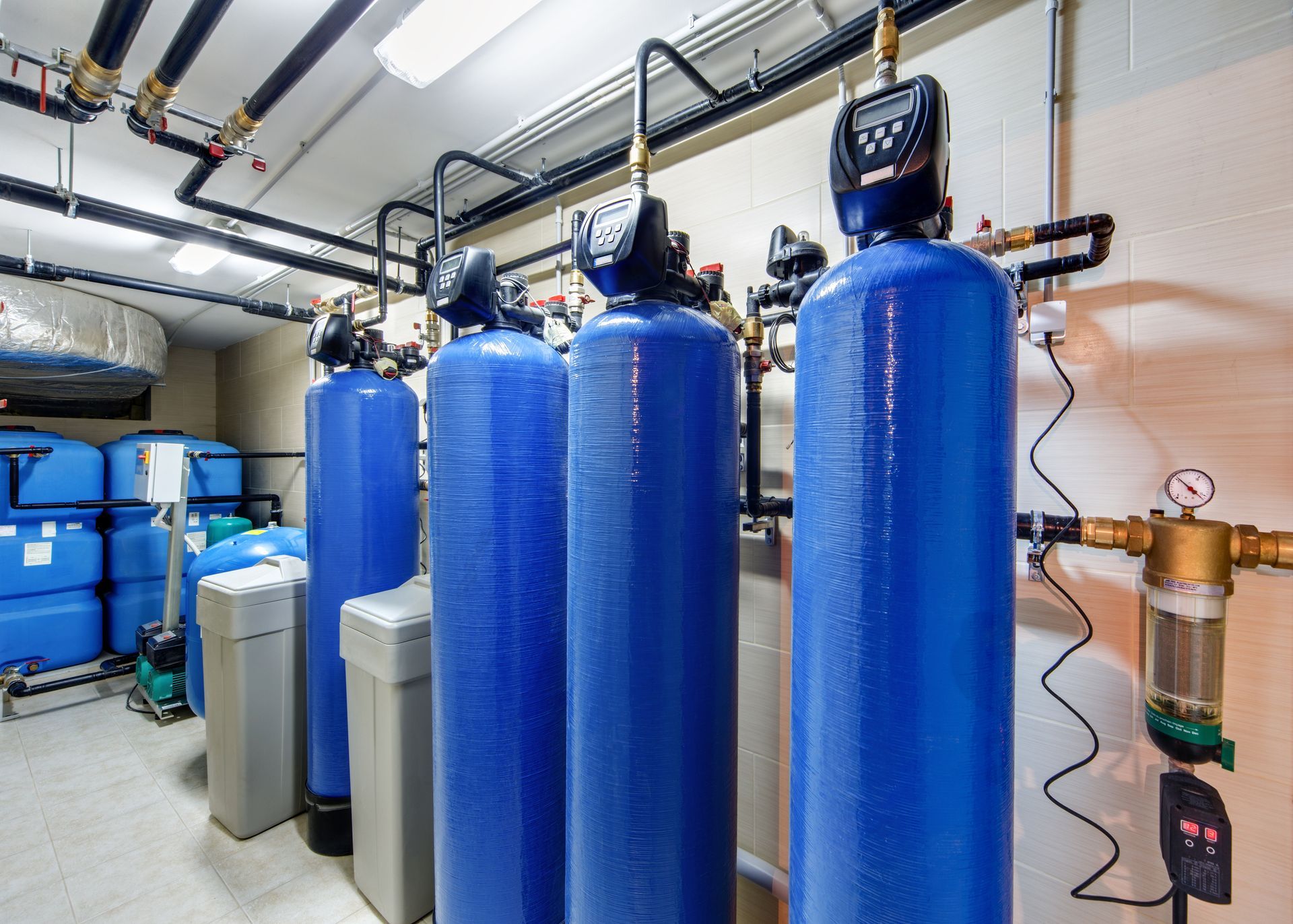 A row of blue water tanks are lined up in a room.