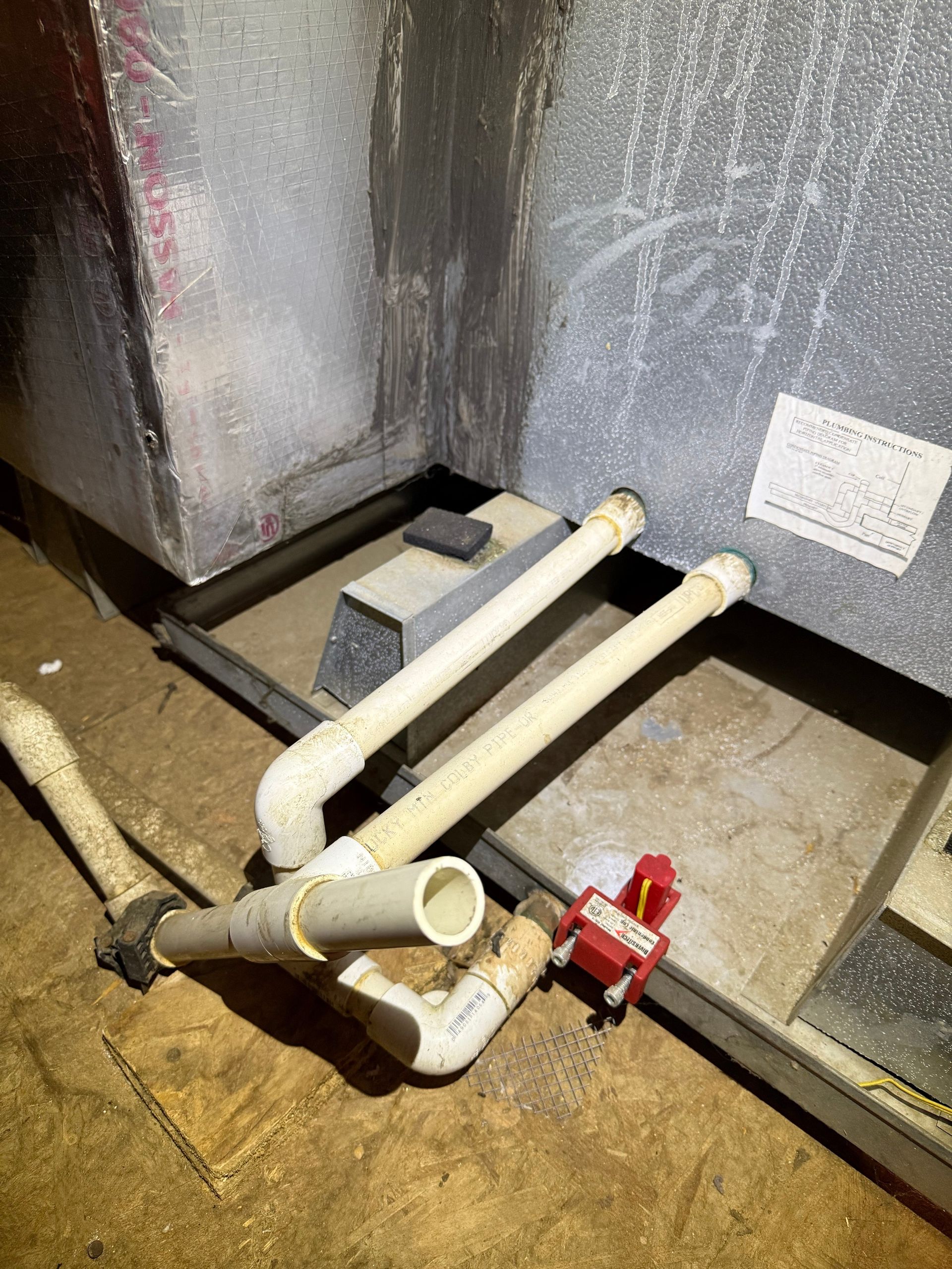 Drain pan with rust, debris, and standing water