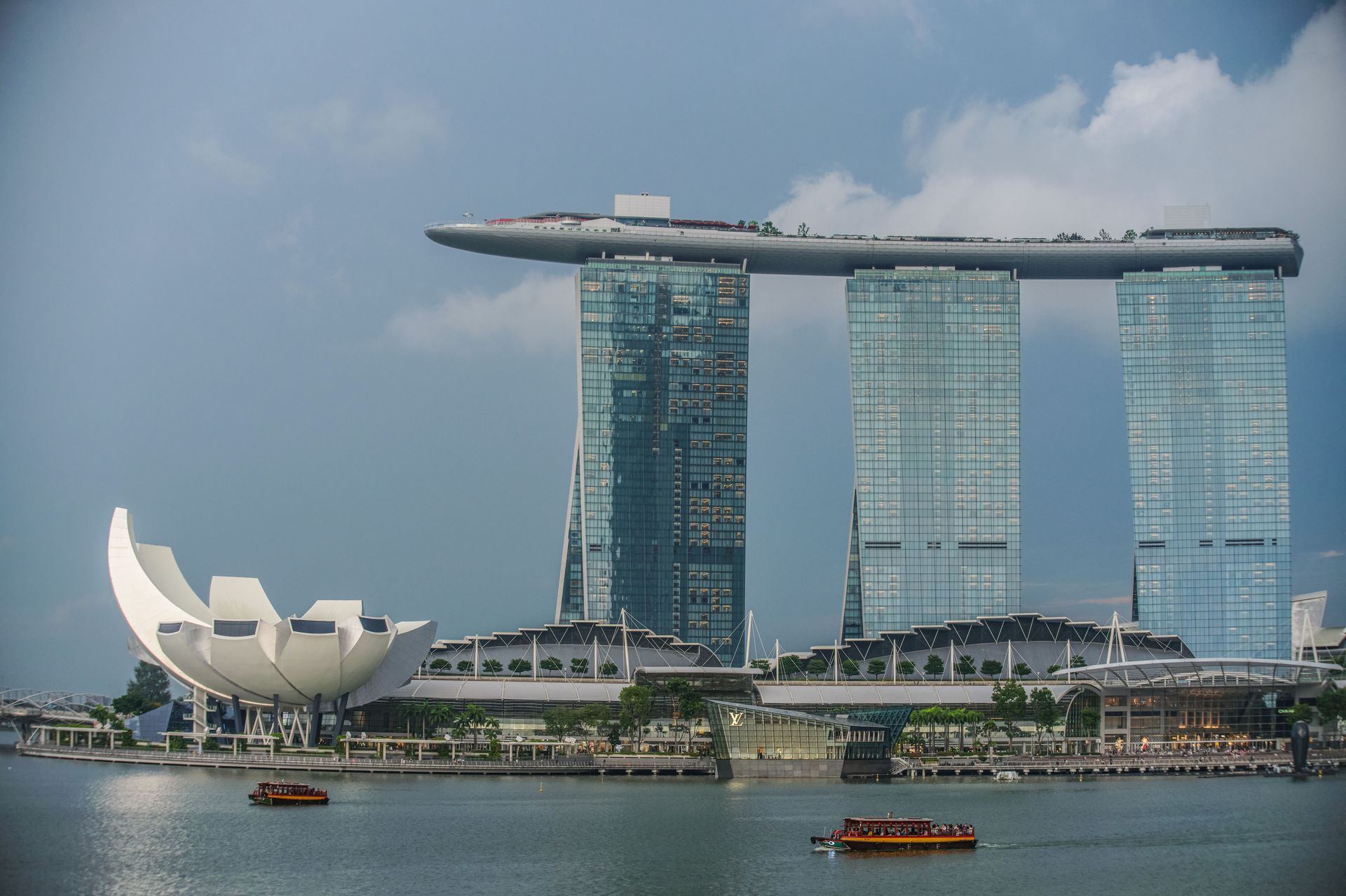 Marina Bay Sands and the white lotus-shaped museum overlooking Singapore’s bay, with boats on calm water