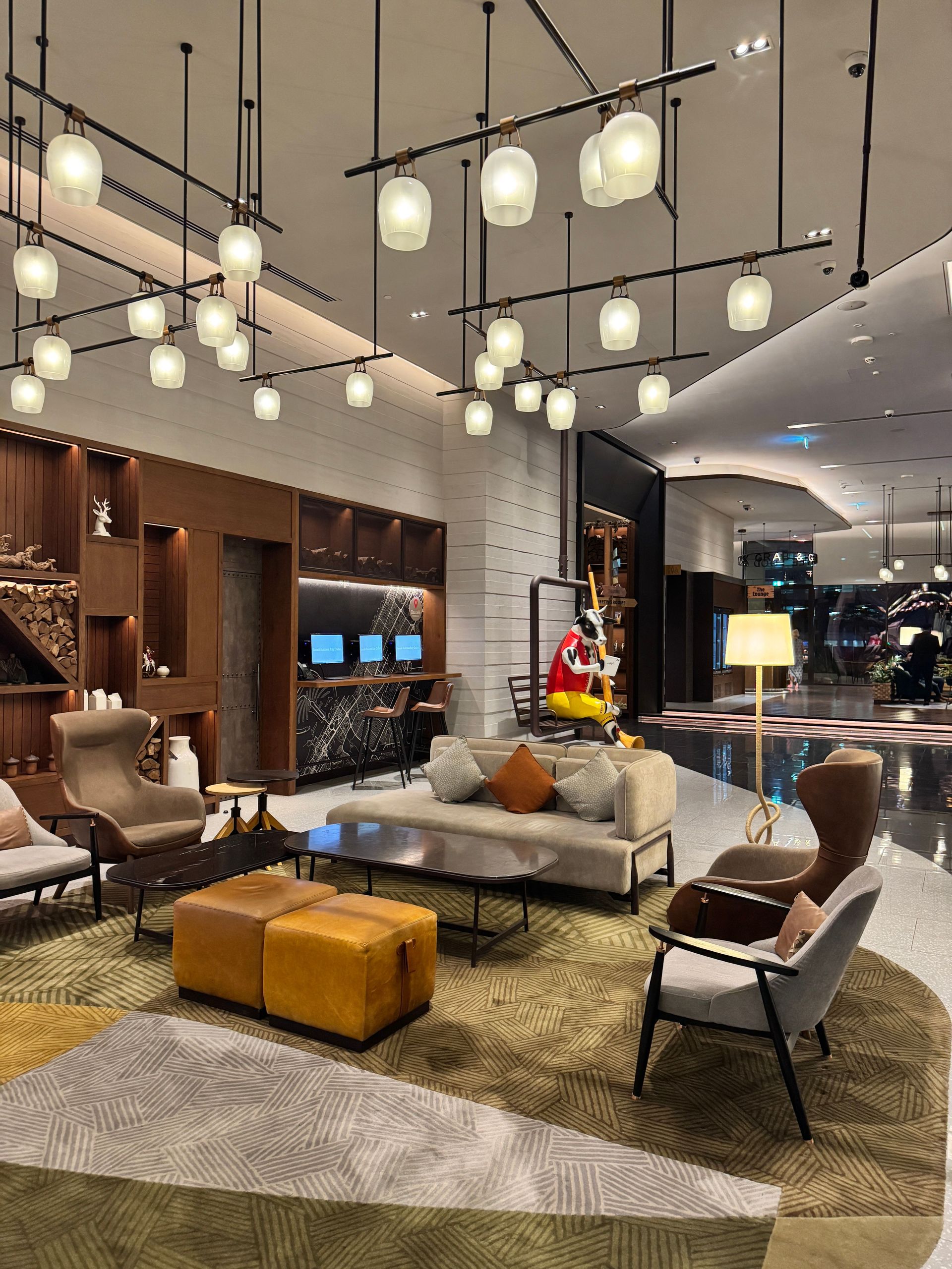 Modern living room showroom with pendant lights, sofas, armchairs, and a coffee table