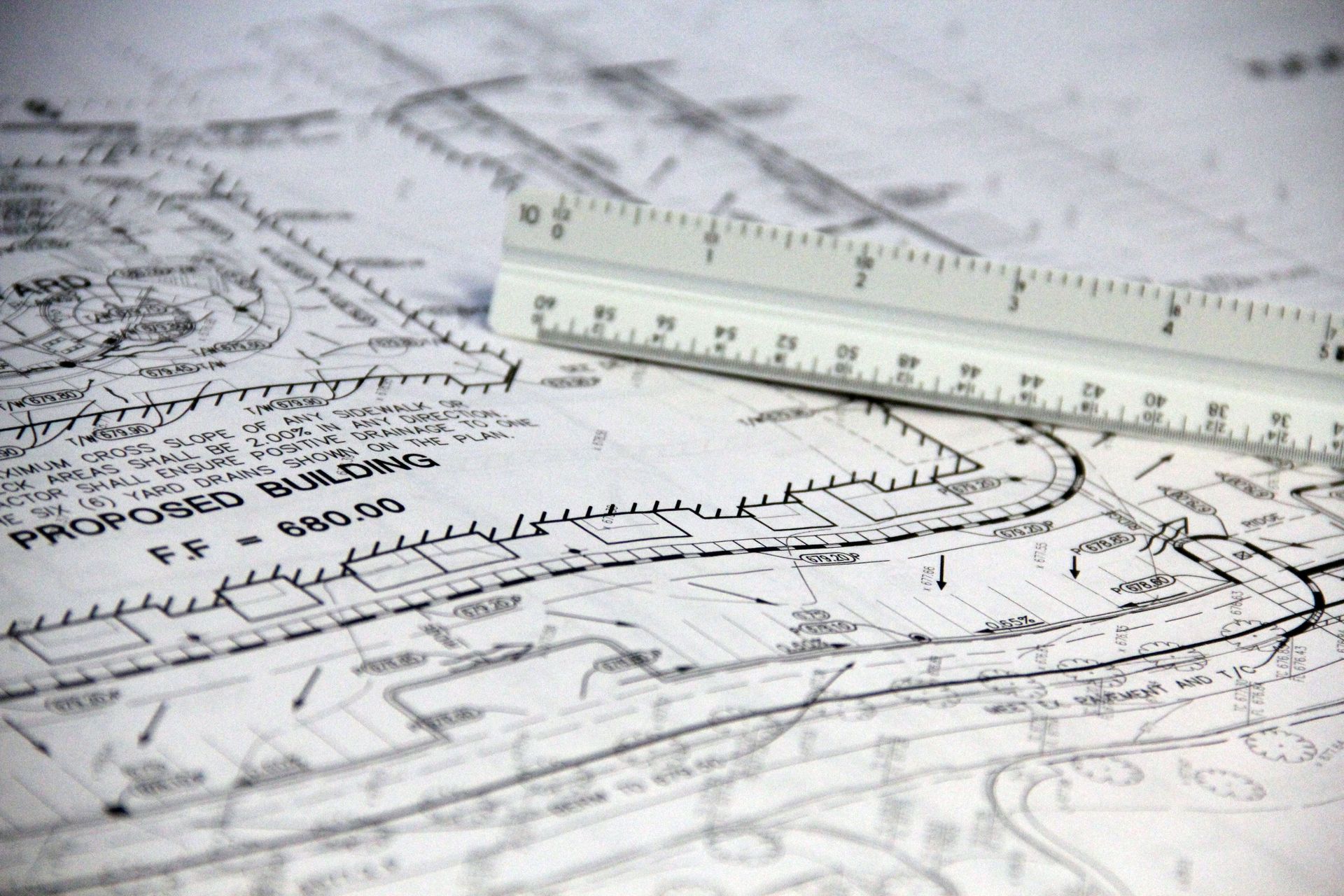 Architectural blueprint with a translucent ruler laid across technical drawings