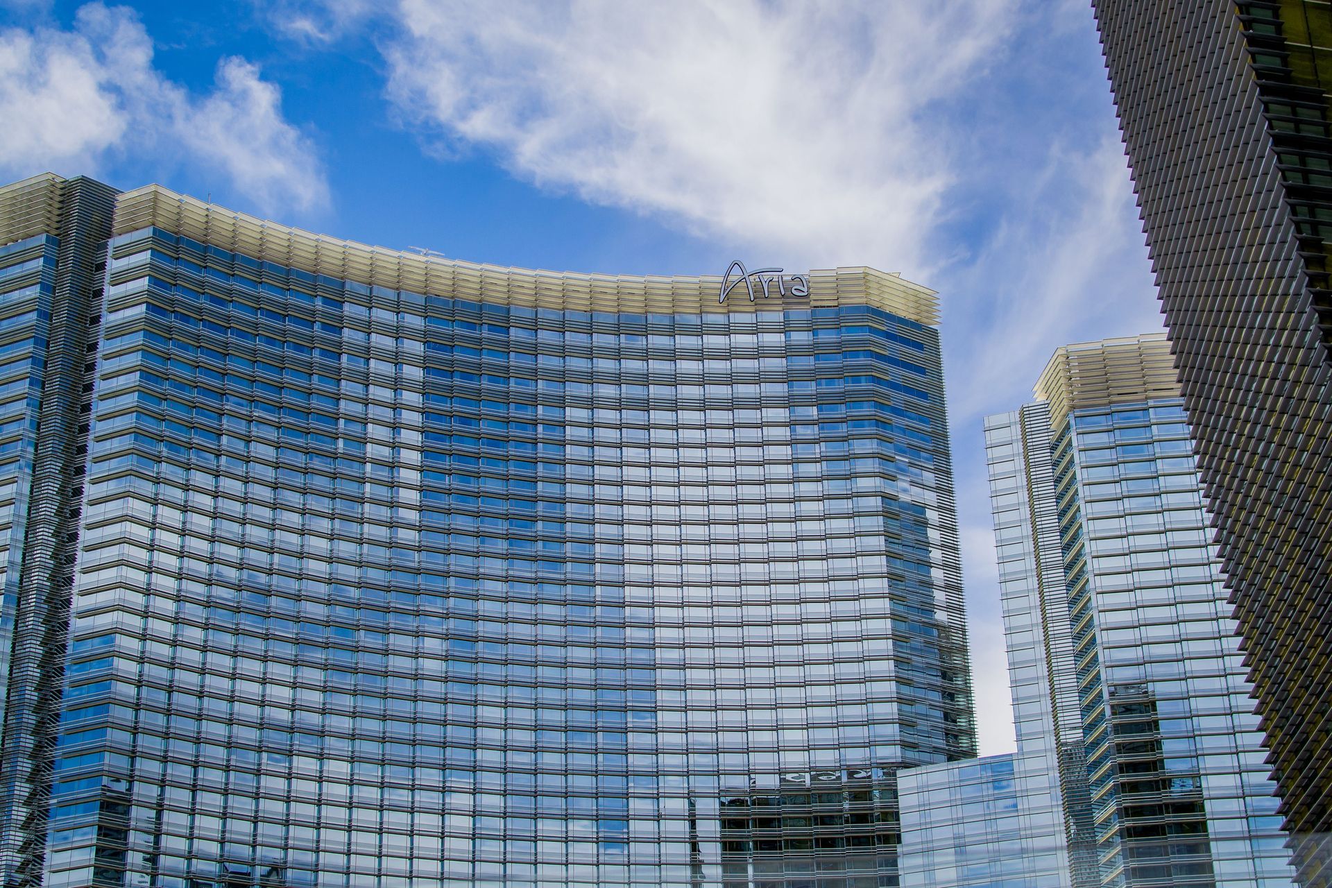 Modern glass skyscrapers reflecting a blue sky with clouds