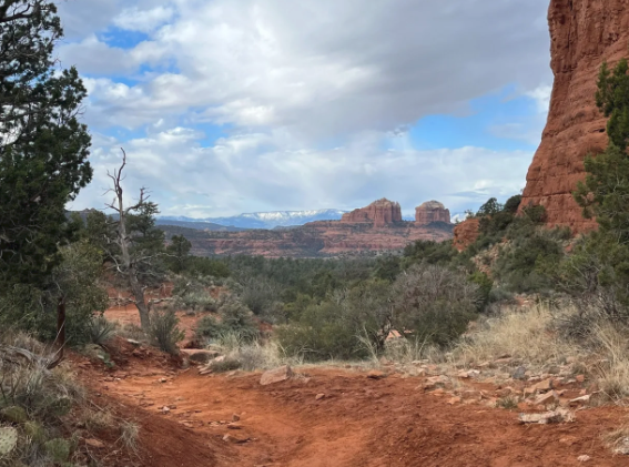 A dirt road in the desert with mountains in the background.