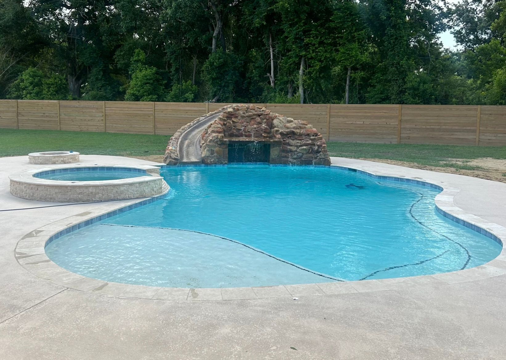 A large swimming pool with a waterfall in the middle