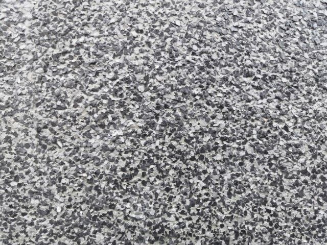 Gray and white speckled stone surface with a rough texture