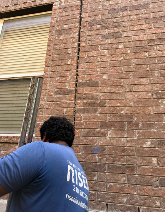A group of men are working on the side of a house.