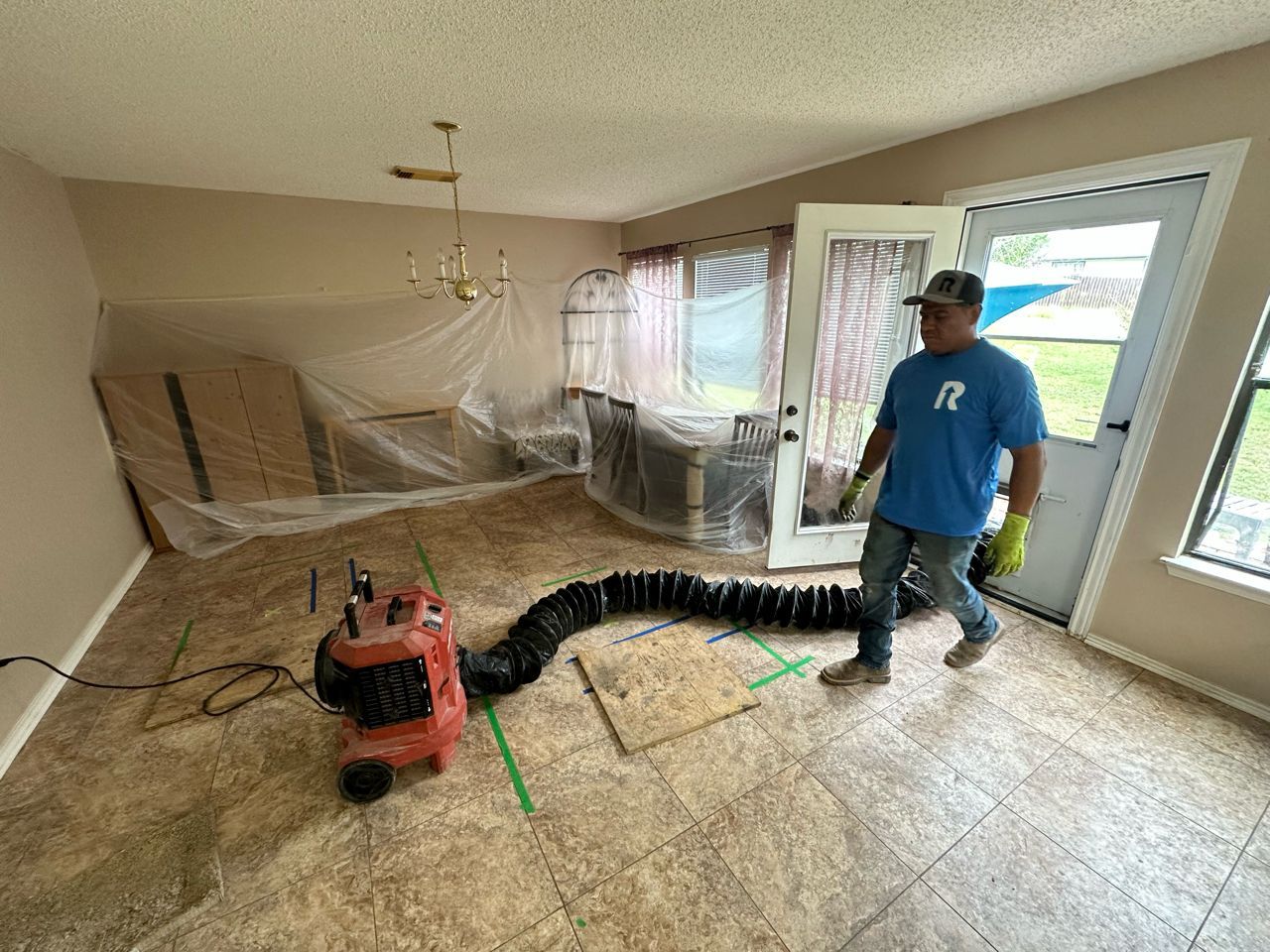 A man is standing in a living room with a vacuum cleaner.