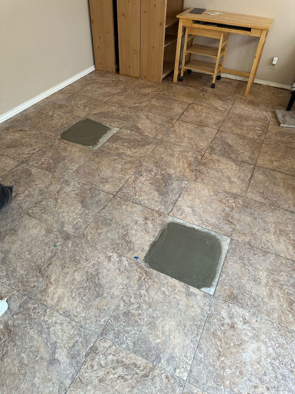 A room with tile floors and a wooden desk.