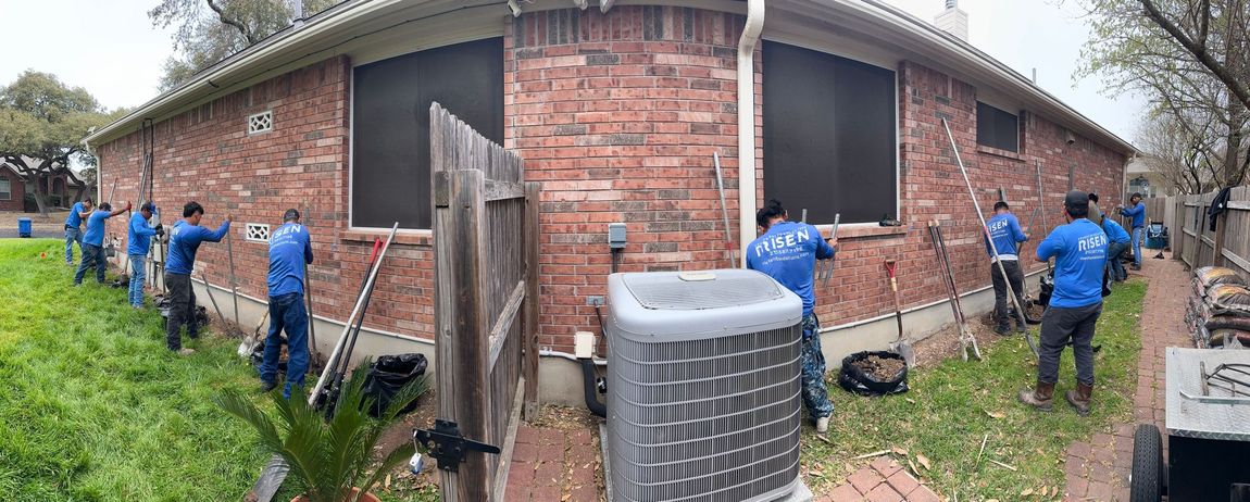 A group of people are working on a brick house.
