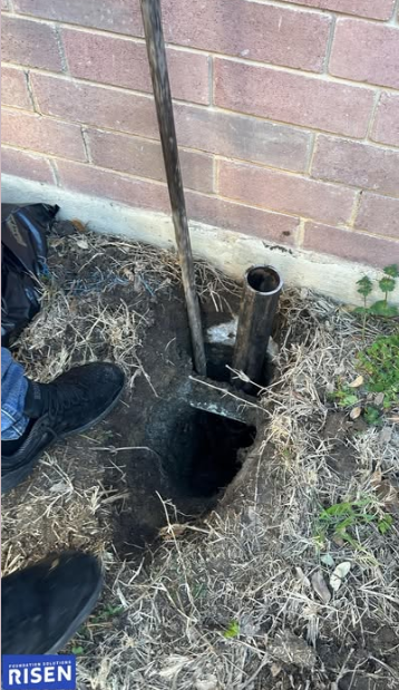 A person is digging a hole in the ground with a shovel.