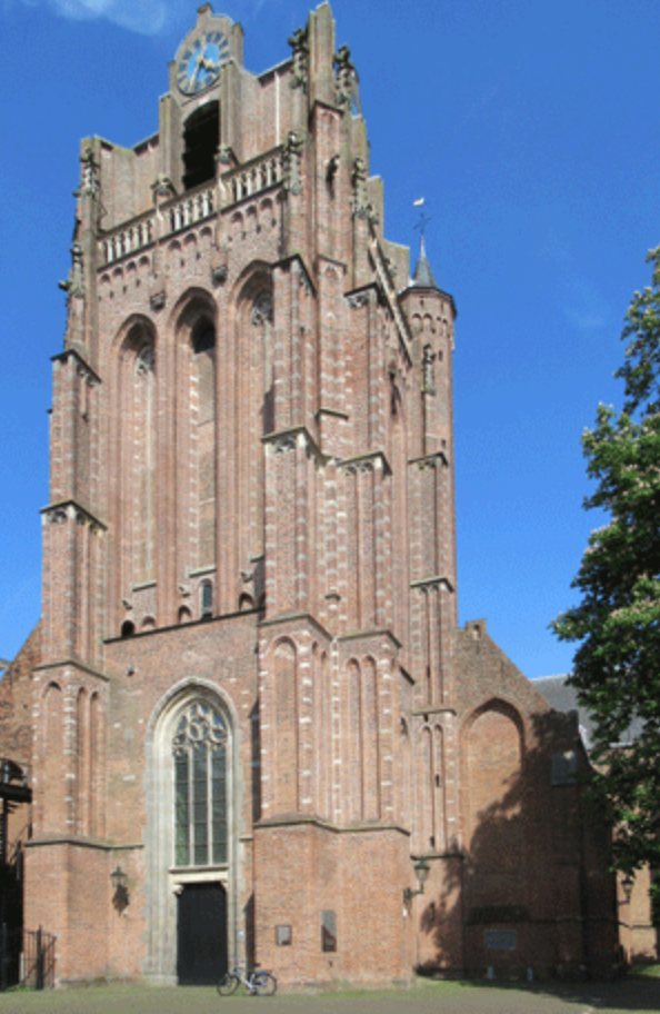 Een stenen kerktoren met klok en boogvensters onder een blauwe hemel.