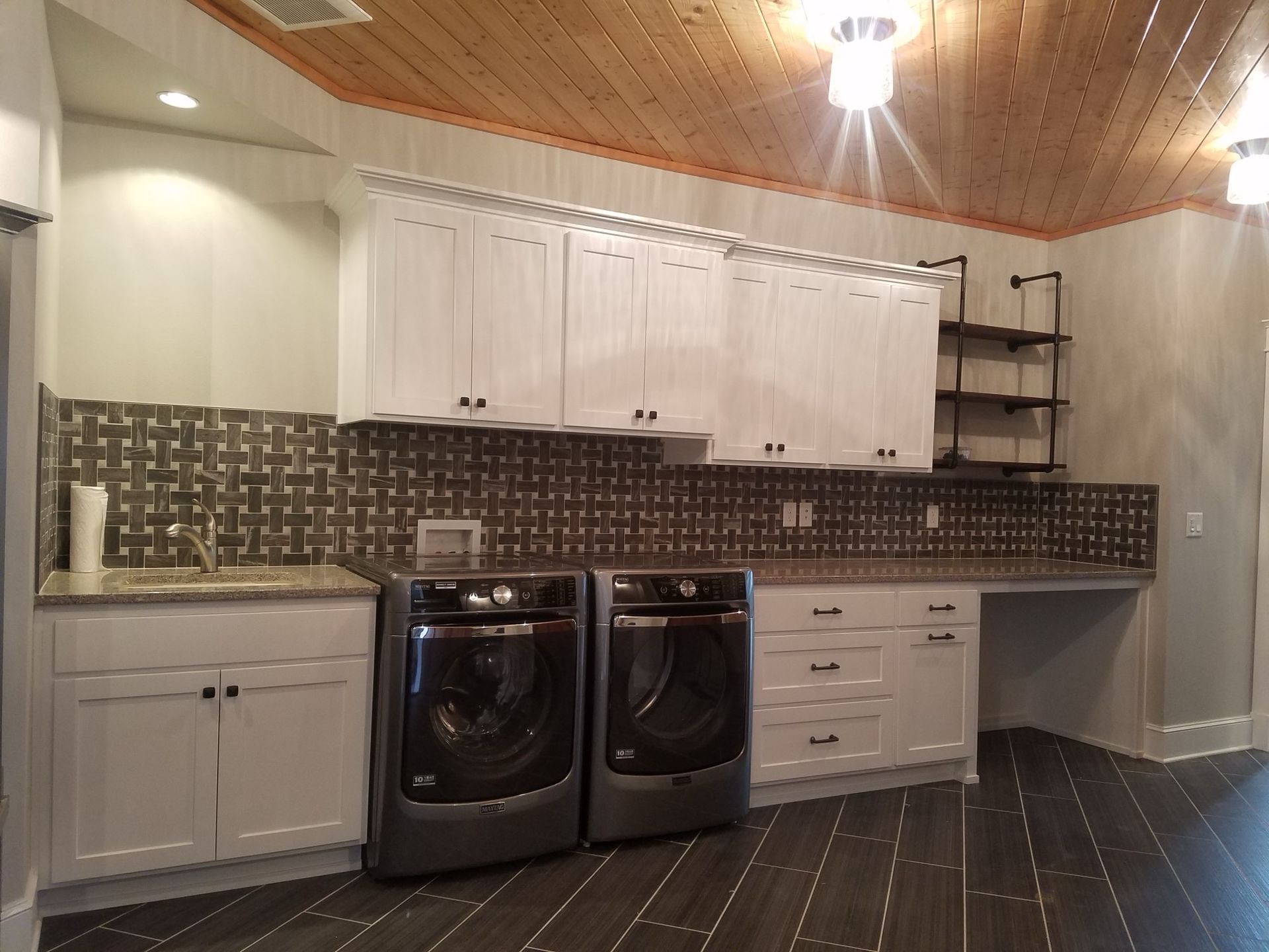 Laundry room with washing machine, cabinets, shelves, and plants Laundry room with washing machine, cabinets, shelves, and plants
