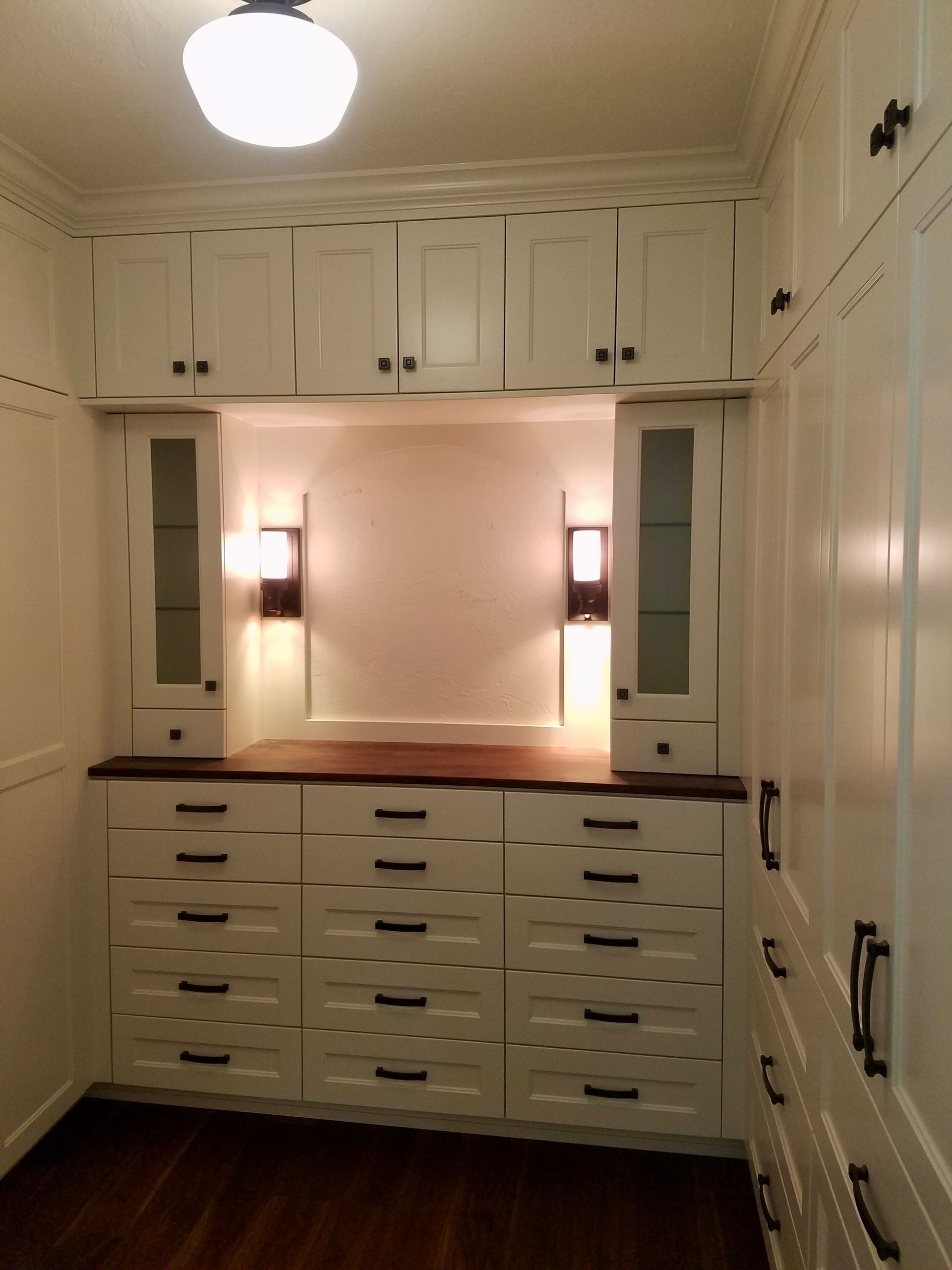Wooden walk-in closet with drawers and hanging clothes Wooden walk-in closet with drawers and hanging clothes