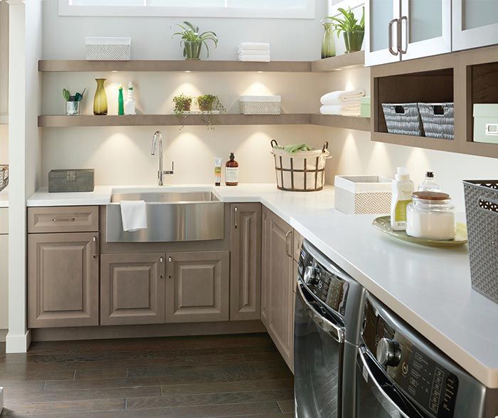 Modern laundry room with sink, cabinets, washer, dryer, shelves, and various supplies. Modern laundry room with sink, cabinets, washer, dryer, shelves, and various supplies.