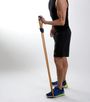 A man in a black tank top and blue shorts is holding a wooden pole.