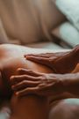 A closeup of hands on the back of a massage therapy patient