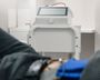 A person is sitting in a chair in front of a machine.