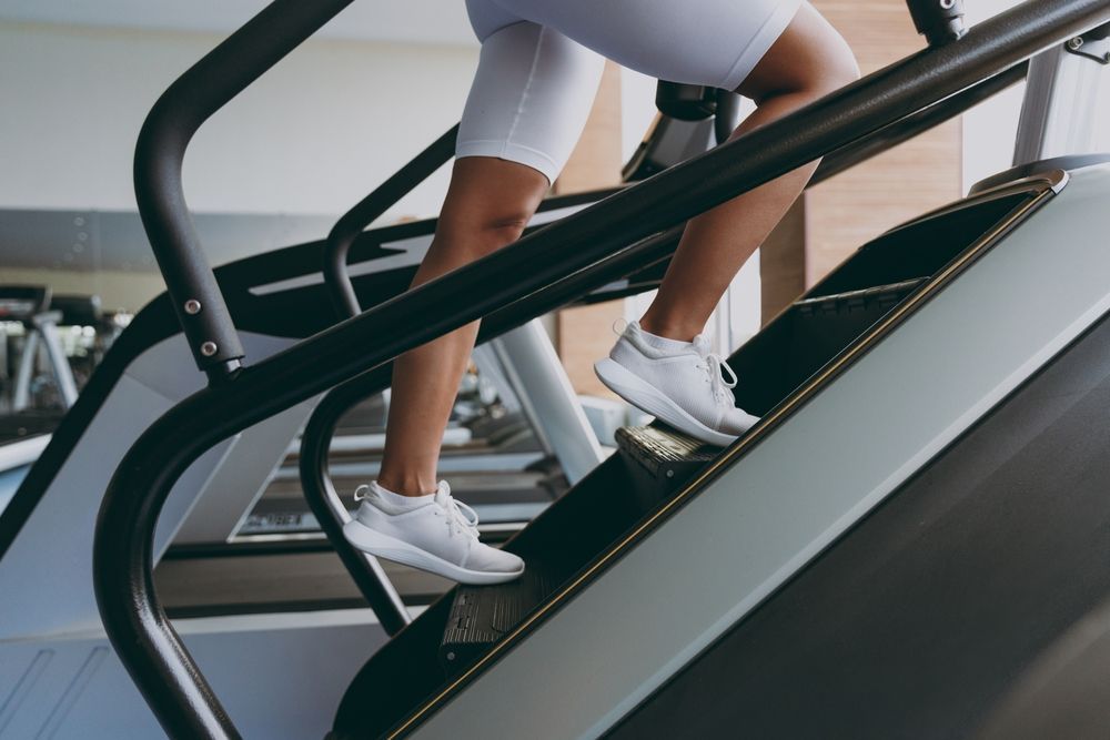 A woman is using an escalator in a gym.